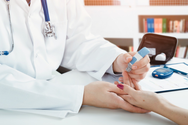 Doctor checking blood sugar level. doctor patient diabetes lancet glucometer blood glucose office concept